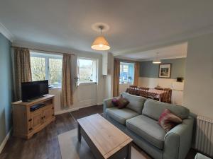 een woonkamer met een bank en een tv bij Westgate Cottage in Pickering