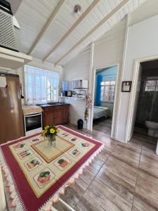 una cucina con un tavolo con un vaso di fiori sopra di Cantinho do Sonho - Chalé Sol a Palhoça Altre 12 foto