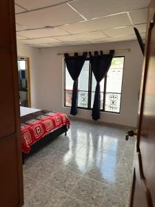 a bedroom with a bed and two large windows at Hotel y Restaurante More in Supía