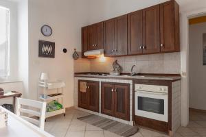 una cucina con mobili in legno, un lavello e una stufa di Seaside holiday inn - free parking a Livorno Altre 15 foto