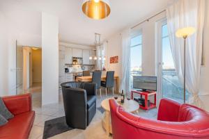 a living room with red furniture and a kitchen at Haus Dünenwald 17 in Zinnowitz