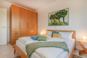 a bedroom with a large bed and a painting on the wall at Haus Dünenwald 17 in Zinnowitz