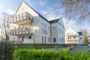 a large white house with a fence in front of it at Haus Dünenwald 17 in Zinnowitz