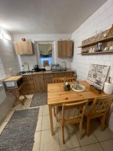 a kitchen with a wooden table and chairs in it at Casa de Vacanta Nora in Oveselu