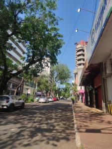 eine Straße mit am Straßenrand geparkten Autos in der Unterkunft Alojamiento AV PIONEROS DEL ÉSTE in Ciudad del Este
