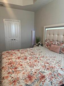 ein Schlafzimmer mit einem großen Bett mit einer Blumenbettdecke in der Unterkunft Cozy, Modern, Family Fun Home near AT&T Stadium, Rangers, Six Flags, Epic Water Park in Arlington