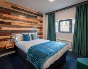 a bedroom with a bed and a wooden wall at The Base Camp Hotel, Nevis Range in Fort William +40 photos