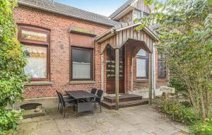 een stenen huis met een tafel en stoelen ervoor bij Zur-alten-Dorfschule in Trennewurth