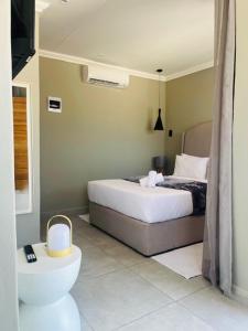a bedroom with a bed and a toilet in it at The Umbrella Shade in Ulundi