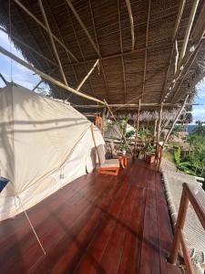 een houten terras met een tent en stoelen op een boot bij Renaco Glamping in Sauce