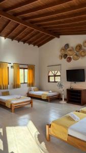 una camera con tre letti e una TV a schermo piatto di Hotel Balcones De Malibu a Medellín Altre 18 foto