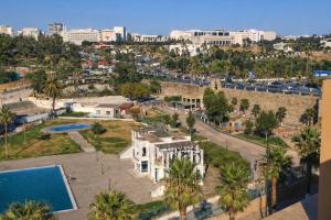 ein weißes Haus mit Palmen und einer Stadt in der Unterkunft Riad Imperial Atlas in Meknès