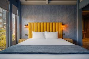 a bedroom with a large bed with a yellow headboard at Pandora House in Mexico City