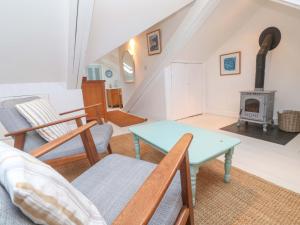 a living room with a table and a fireplace at Badgers Loft in Penzance