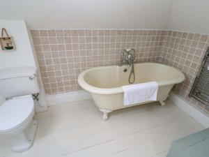 a bathroom with a bath tub and a toilet at Badgers Loft in Penzance +9 photos