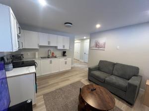 een keuken en woonkamer met een bank en een tafel bij Bright & cozy apartment in Moncton +7 foto's