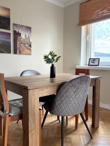 einen Esstisch und Stühle mit einem Holztisch in der Unterkunft Apartament na Błoniach in Sanok