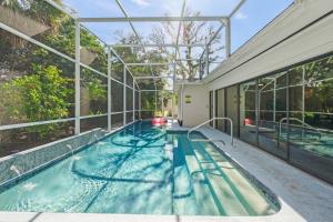 an indoor swimming pool in a building with a glass ceiling at Toes in the Water - Pool Home on Siesta Key in Siesta Key +42 photos