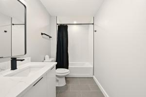 a white bathroom with a toilet and a shower at Union market Lux condo in Washington, D.C. +10 photos