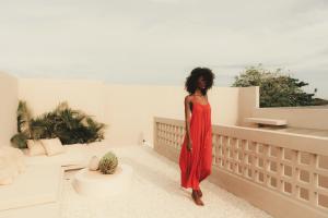 a woman in a red dress standing on a balcony at NORI Boutique Villas Uluwatu - Breakfast Available in Uluwatu