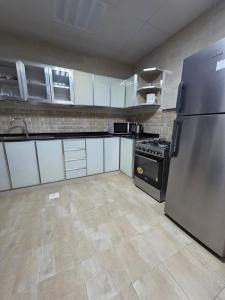a kitchen with a stainless steel refrigerator and appliances at Opera43 Spacious & Central in Ghubrah