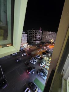 a view from a window of a parking lot at night at Opera43 Spacious & Central in Ghubrah