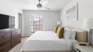 ein weißes Schlafzimmer mit einem Bett und einem Fernseher in der Unterkunft Landing Apartments - Denton in Denton + 62 Fotos