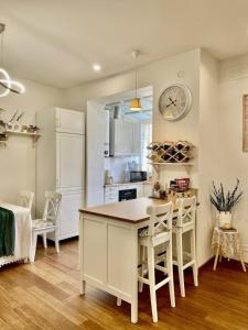 een keuken met witte kasten en een tafel en stoelen bij Happy Nest Tuscany in Castiglion Fiorentino