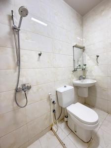 a bathroom with a shower and a toilet and a sink at Opera47 Spacious & Central in Ghubrah