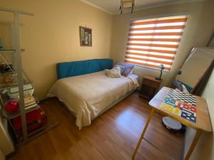 una piccola camera da letto con un letto e una finestra di Refugio urbano a Villarrica