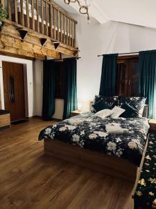 ein Schlafzimmer mit einem Bett mit einer schwarz-weißen Bettdecke in der Unterkunft Pstrągowo - domki z jacuzzi in Machowa