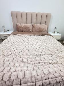 a bedroom with a large bed with two tables at Opera47 Spacious & Central in Ghubrah