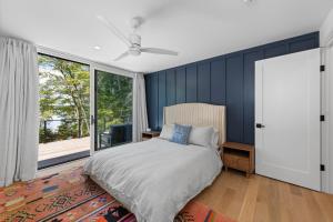 een slaapkamer met een bed en een groot raam bij NEW! Tilted Pine - Lake Access Modern Home in Center Harbor