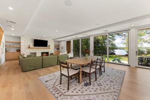 een eetkamer en woonkamer met een tafel en stoelen bij NEW! Tilted Pine - Lake Access Modern Home in Center Harbor