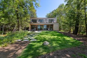 een huis in het bos met een tuin bij NEW! Tilted Pine - Lake Access Modern Home in Center Harbor