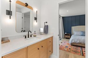een badkamer met een wastafel en een slaapkamer met een bed bij NEW! Tilted Pine - Lake Access Modern Home in Center Harbor +37 foto's