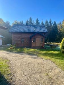a log cabin with a metal roof on a yard at Gajówka Wiry in Pawłowa