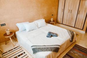 a bedroom with a bed with a remote control on it at Cool Surfers Morocco in Agadir