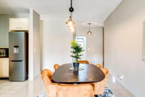a dining room with a table and chairs at Belina - Knightsbridge Prestige Suite in Cape Town