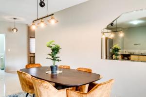 a dining room with a wooden table and chairs at Belina - Knightsbridge Prestige Suite in Cape Town