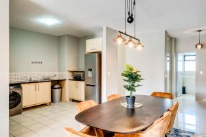 a kitchen and dining room with a table and chairs at Belina - Knightsbridge Prestige Suite in Cape Town +61 photos