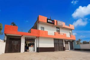 un edificio con un cartello QOS sul lato di SPOT ON Royal Palace a Mandhana