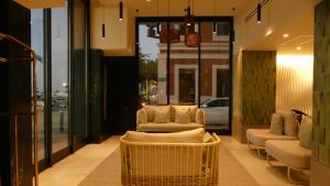 a lobby with couches and chairs in a building at Seven Crown La Paz Malecon in La Paz