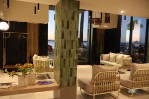 a living room with chairs and a column in the middle at Seven Crown La Paz Malecon in La Paz