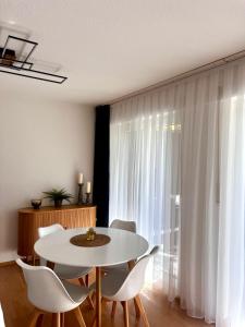 een eetkamer met een witte tafel en witte stoelen bij City Appartment Neuss in Neuss
