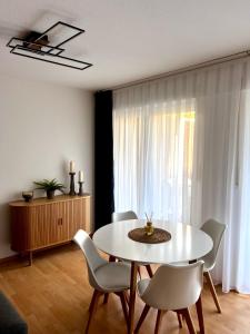 een eetkamer met een witte tafel en stoelen bij City Appartment Neuss in Neuss