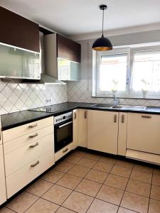 een keuken met witte kasten en een zwart aanrechtblad bij City Appartment Neuss in Neuss +1 foto
