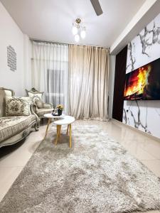 a living room with a couch and a table at Opera67 Spacious & Central in Ghubrah