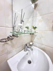 a bathroom with a sink and a mirror at Opera67 Spacious & Central in Ghubrah +7 photos