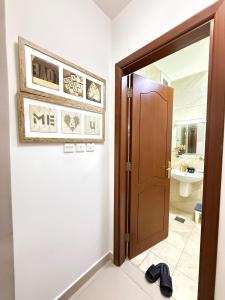 a room with a door and a bathroom with a sink at Opera67 Spacious & Central in Ghubrah